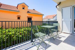 a patio with a table and chairs on a balcony at Pomalo apartments Vodice in Vodice