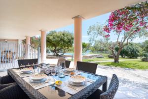 une table à manger avec des chaises et des verres sur une terrasse dans l'établissement La Vela Arancione, à Orosei