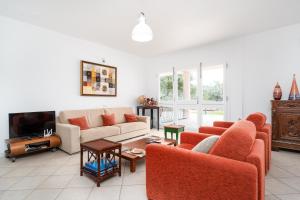 un salon avec deux canapés et une télévision dans l'établissement La Vela Arancione, à Orosei