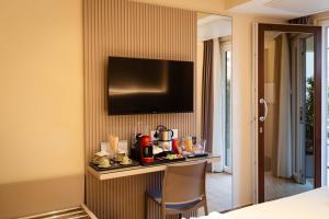 a hotel room with a table and a television on a wall at Residenza Gurnea - Free Private Parking in Tropea