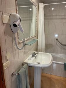 a bathroom with a sink and a mirror and a shower at Apartamentos Colón2 in Playa de las Americas +15 photos
