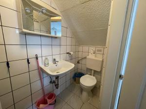 a small bathroom with a toilet and a sink at Tabán Vendégház in Balatonlelle