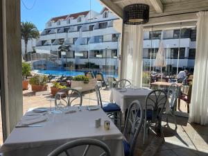 a patio with tables and chairs and a building at Apartamentos Colón2 in Playa de las Americas