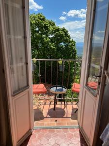 una porta aperta su un balcone con tavolo e sedie di Au coeur du village avec petit balcon plein sud a Tourtour