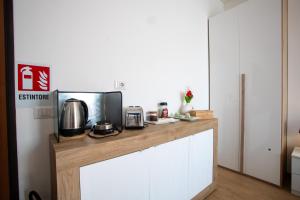 a kitchen with a counter with a coffee maker and a microwave at Blue's Place - Vicino Stazione Chiasso in Como +13 photos