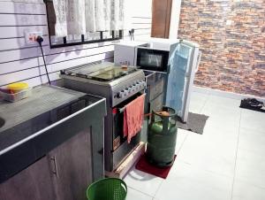 a kitchen with a stove and a refrigerator at Pazuri Homes 1 Bedroom Kisimani Heights Mombasa in Mombasa +3 photos