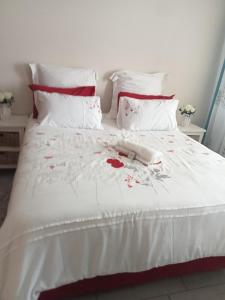 a white bed with red flowers on it at Mandoo guesthouse in Vosburg
