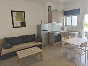 a living room with a couch and a table at Chrissos apartment in Agios Padeleimon +2 photos