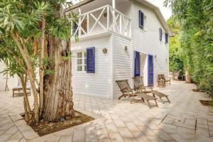 a patio with benches and a building with blue shutters at Onde blu in Marina di Campo
