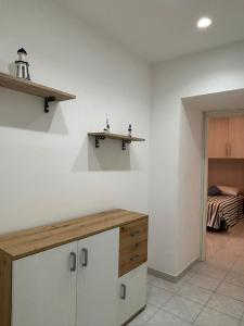 a kitchen with a counter and a room with a bed at Fefalù House in Ischia Town +13 photos