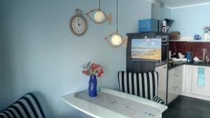 a kitchen with a table and two chairs and a tv at Ostseeeule in Graal-Müritz