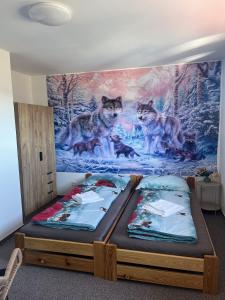 two beds in a room with a painting of wolves at Penzion Axiom in Frymburk +54 photos