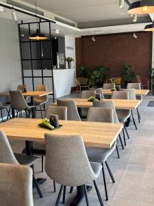 rząd drewnianych stołów i krzeseł w pokoju w obiekcie Abton Hotel w Łodzi