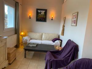 La Maison de Jeanne في Châteney: غرفة معيشة مع أريكة وطاولة قهوة