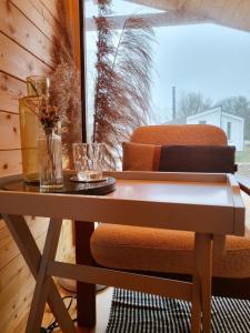 a table and a chair in a room with a window at 307 Tiny Elbhouse in Bleckede
