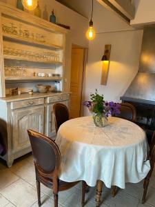 La Maison de Jeanne في Châteney: مطبخ مع طاولة عليها مزهرية من الزهور