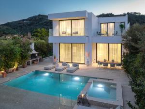 a house with a swimming pool in front of it at The White Luxury Villa - Private Seaview Villa with Pool by Villa Mana Gers in Vasilikos