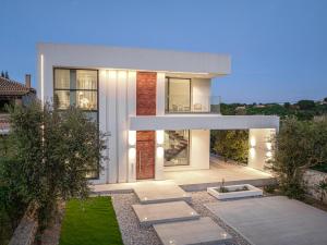 a large white house with a garden in front of it at The White Luxury Villa - Private Seaview Villa with Pool by Villa Mana Gers in Vasilikos
