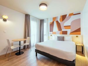 Postel nebo postele na pokoji v ubytování Aparthotel Adagio Access Paris Asnières