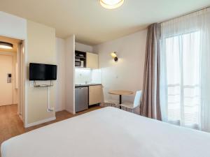 TV a/nebo společenská místnost v ubytování Aparthotel Adagio Access Paris Asnières