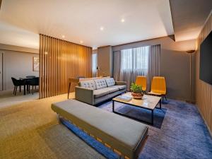 a living room with a couch and a table at Pullman Sao Paulo Guarulhos Airport in Guarulhos