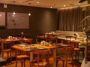 a dining room with wooden tables and chairs at Pullman Sao Paulo Guarulhos Airport in Guarulhos