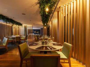a restaurant with a table and chairs and tables and chairsktop at Pullman Sao Paulo Guarulhos Airport in Guarulhos