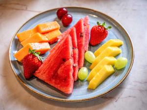 a plate of fruit and vegetables on a table at Pullman Sao Paulo Guarulhos Airport in Guarulhos