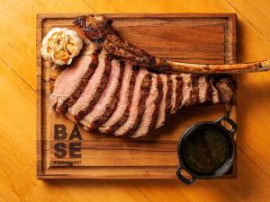 a cutting board with a piece of meat on a table at Pullman Sao Paulo Guarulhos Airport in Guarulhos
