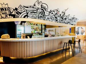 a bar with a wall covered in graffiti at Pullman Sao Paulo Guarulhos Airport in Guarulhos