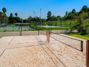 a tennis court with a net in the sand at Pullman Sao Paulo Guarulhos Airport in Guarulhos