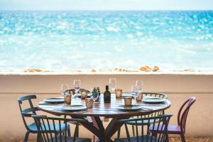 Una mesa con vasos y botellas de vino en la playa. en Tamarit Beach Resort, en Tamarit