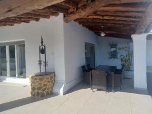 a patio with a table and chairs and a wooden ceiling at Villa Can Goldi con vistas al mar in Sant Josep