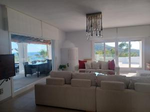 a living room with a couch and a dining room at Villa Can Goldi con vistas al mar in Sant Josep