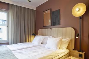 a bedroom with a large bed with white pillows at Scandic Malmen in Stockholm