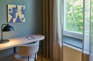 a desk with a chair next to a window at Scandic Malmen in Stockholm