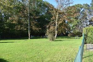 a fence in a field with trees in the background at Ferienwohnung Windhund in Dornum