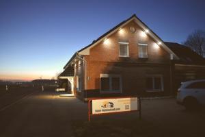 a house with a sign in front of it at Ferienwohnung Windhund in Dornum