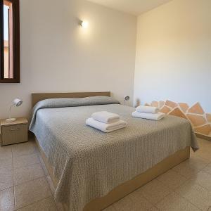 a bedroom with a bed with towels on it at Casa vacanze Sardegna, Torre dei Corsari Costa Verde in Torre Dei Corsari