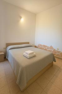 a bedroom with a bed with two towels on it at Casa vacanze Sardegna, Torre dei Corsari Costa Verde in Torre Dei Corsari
