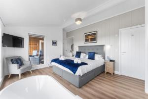 a bedroom with a large bed and a chair at Arrochar View in Langbank