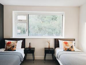 a bedroom with two beds and a window at Bee Stays - Rostherne House in Warrington