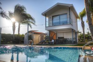 a villa with a swimming pool and a house at Oasis By The Sea - Cyprus in Larnaca