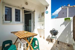 un piccolo balcone con tavolo e griglia di Casa Estrela do Mar a Ericeira