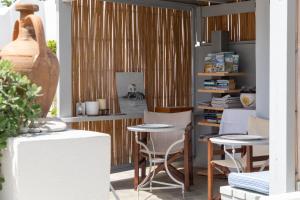 a room with tables and chairs and a book shelf at Villa Arni Andros - Βίλα ΑΡΝΗ in Batsi