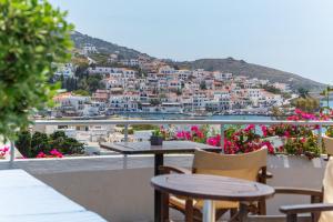 a table and chairs on a balcony overlooking a city at Villa Arni Andros - Βίλα ΑΡΝΗ in Batsi +40 photos
