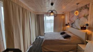 a bedroom with a bed and a large window at Central Riverside Apartments in Jēkabpils