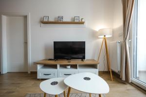 a living room with two white chairs and a tv at Apartman Anika Banja Koviljača in Banja Koviljača