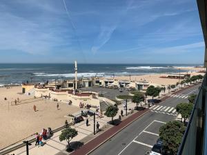 a view of a beach with a building and the ocean at Póvoa TOP - Beachfront in Póvoa de Varzim
