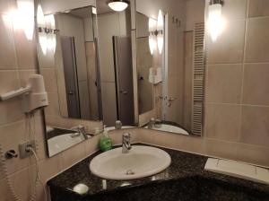 un bagno con un lavandino e un grande specchio di Kranich - Ferienwohnung mit Terrasse a Dewichow Altre 41 foto